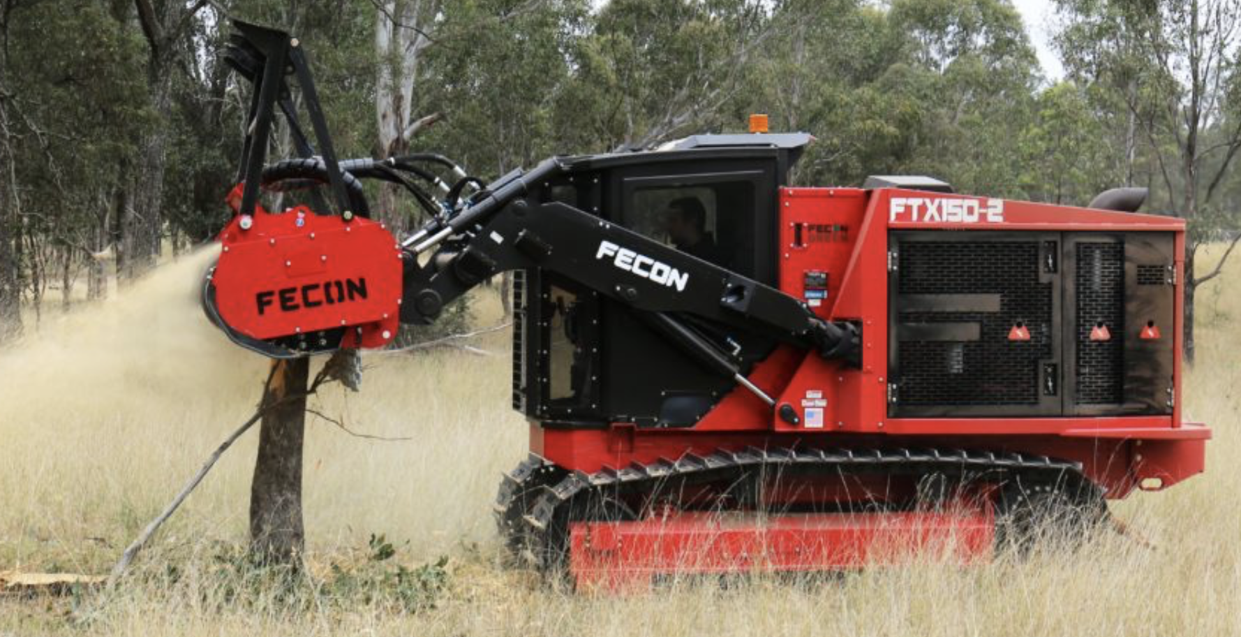 Forestry mulching skid steer with Fecon head clearing overgrown brush in wooded area